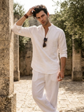 Man wearing a white stand-collar kurta shirt and white trousers outdoors.