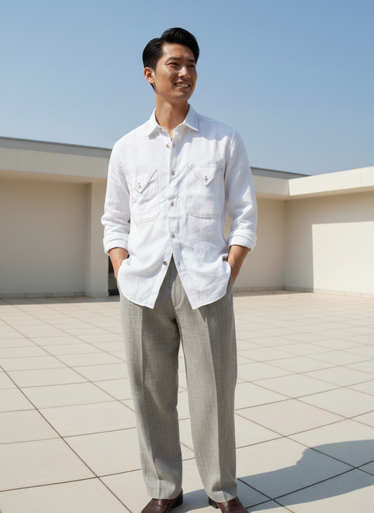 Man wearing a white shirt and light gray pants on a rooftop with a clear blue sky.