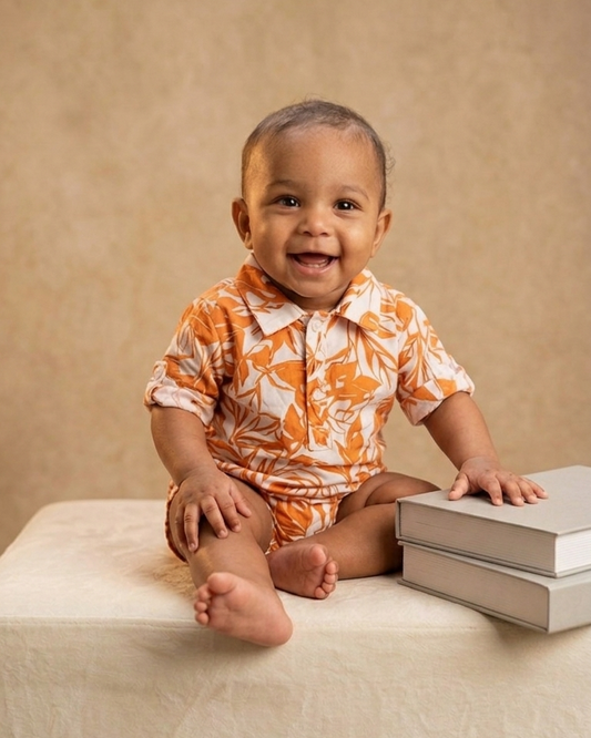 Close-up of orange and grey print on baby romper, soft gentle detailing Moon N Lotus